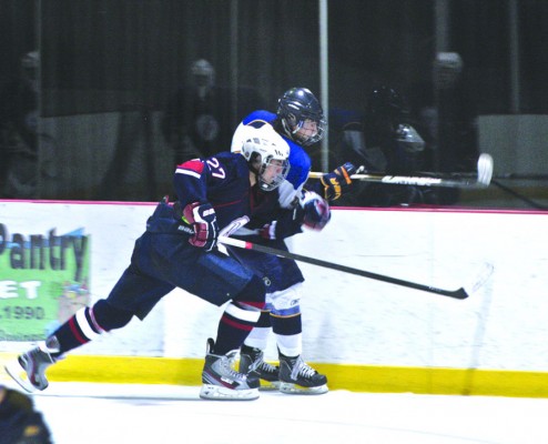 Using a shoulder, junior Jack McClelland slams one of the St. Louis Blues’ players into the glass.