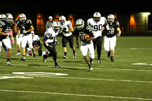 As he runs up the field, sophomore Johnny Dunlap gets a first down for the Timberwolves. Photo by Morgan Vietti.