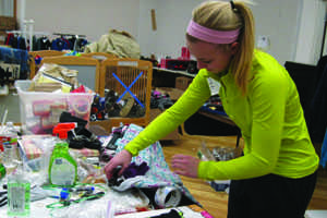 Junior Lexie Logue sorts donations and takes off price tags for the teen gift 
department at JCCB. Photo by Anna Welch.