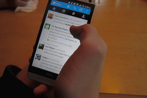 Freshman Jack Jennings scrolls through his Twitter app at the kitchen table.