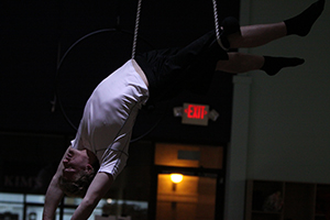 Senior Andrew Woods situates his right leg in a rope for support and drapes his back over the trapeze bar. 