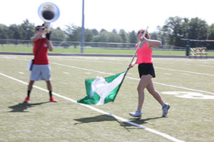 Junior Charlee Striebinger holds her flag strong as she strides across the field.