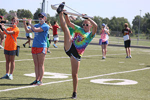 Freshman Claire Boomer extends her leg in a leg hold using her rifle.