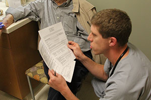 Jenson going over paperwork with his patient.