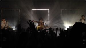 The crowd goes wild and sings along as Matty stands in front of the The 1975's signature frame.