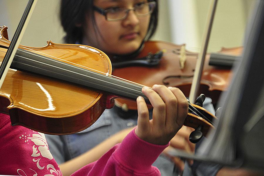 Sophomore Amira Bajracharya practices her violin with the Pit Orchestra in preparation for the musical.