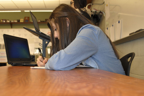 Freshman Rachel Holzer takes notes during a practice debate after school.