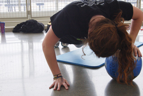 Sophomore Ashlyn Farnow completes a push up using a medicine ball during pre-season conditioning.   