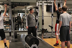 New football coach Anthony Orrick leads a weight training session for students planning on trying out for the 2015-2016 team.
