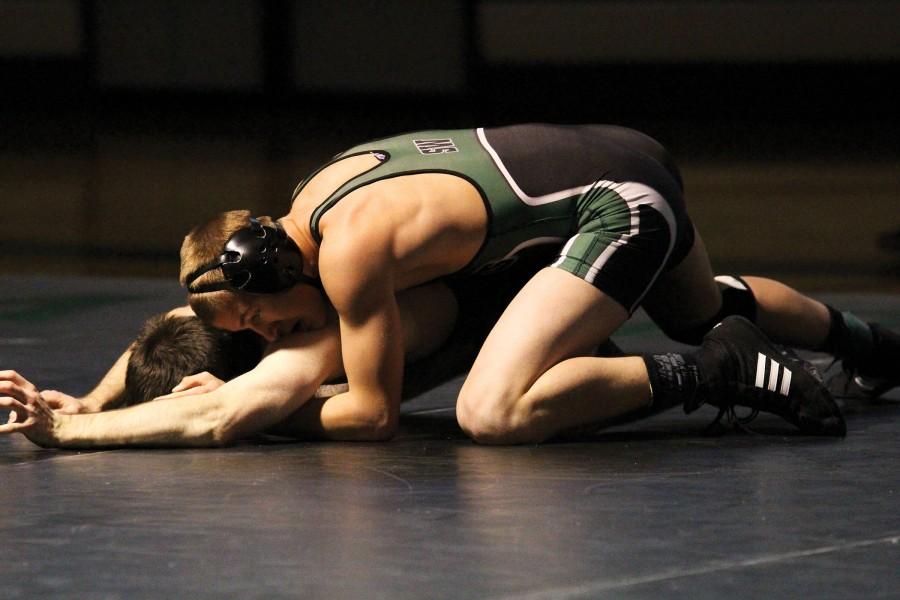 Wrestling in green, senior Marty Verhaeghe aims to pin his competitor, fellow varsity wrestler senior Jake Willson, at the Black and Green Duel on Nov. 28. Verhaeghe won the scrimmage against Willson 3 to 1.