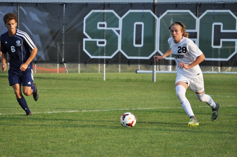 Junior Matthew Weaver carries the ball down the field before crossing the ball to a teammate.