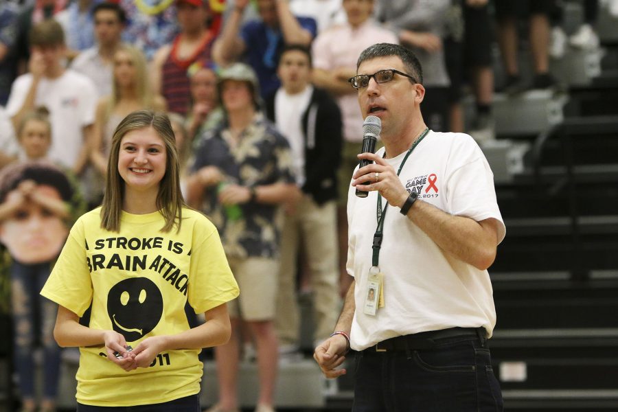 Principal Scott Roberts tells the crowd at the game how to recognize the signs of a stroke. 