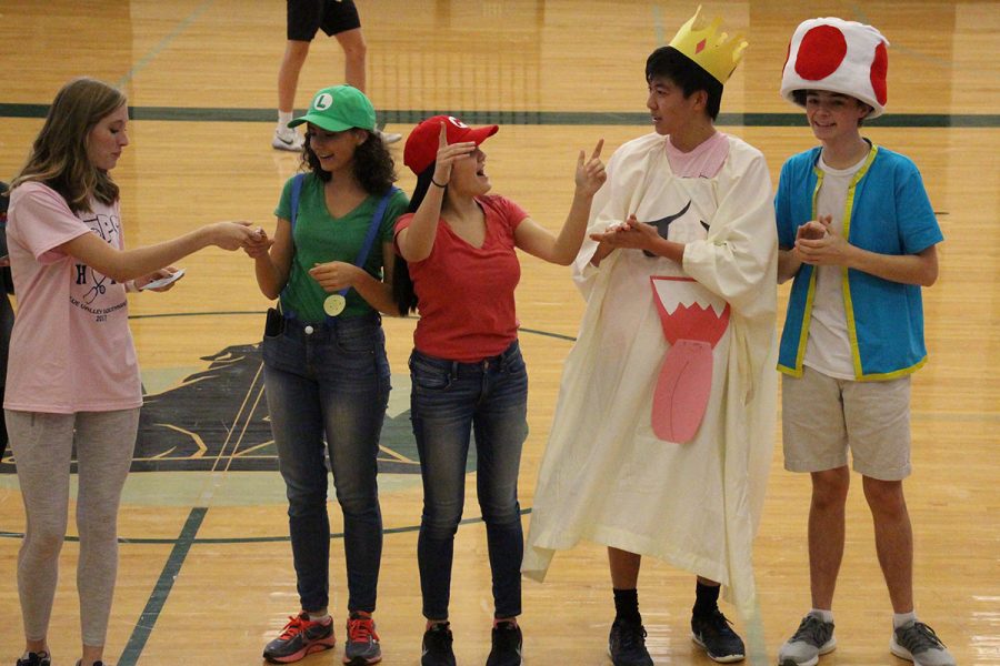 Team+Mario%2C+seniors+Rachel+Holzer%2C+Sumaya+Hussani+and+Nick+Castle+and+junior+Ted+Shi%2C+accepts+the+prize+for+best+costume+from+senior+Evie+Peterson.