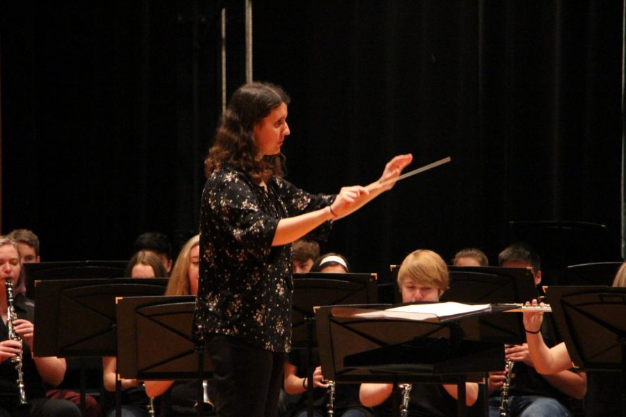 With arms lifted, assistant band director Laura Bock conducts her students. She conducted the band through two songs at the band festival on Thursday April 4.