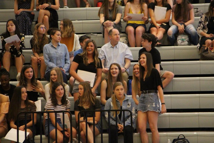 After being recognized for their successes, Brooke Davis and Carson Craft laugh in the bleachers.