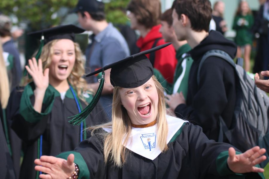 Smiling to her friends, senior Violet Holman finishes the tradition of walking through courtyard. 