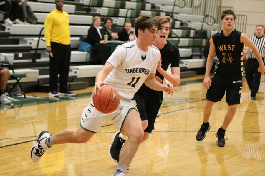 Sophomore Tyler Sardelli battles for the ball at the boys basketball game.