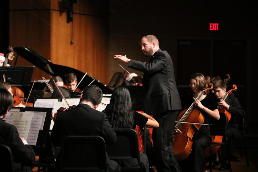 Orchestra director Ethan Loewen moves his hands while conducting a piece for the orchestra quarterly concert.
