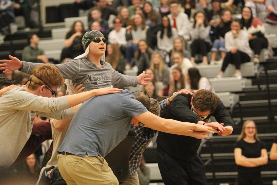 "Flying" on the "Titanic," freshman Anthony Melick performs with his swim and dive teammates at the Winter Sports Assembly.