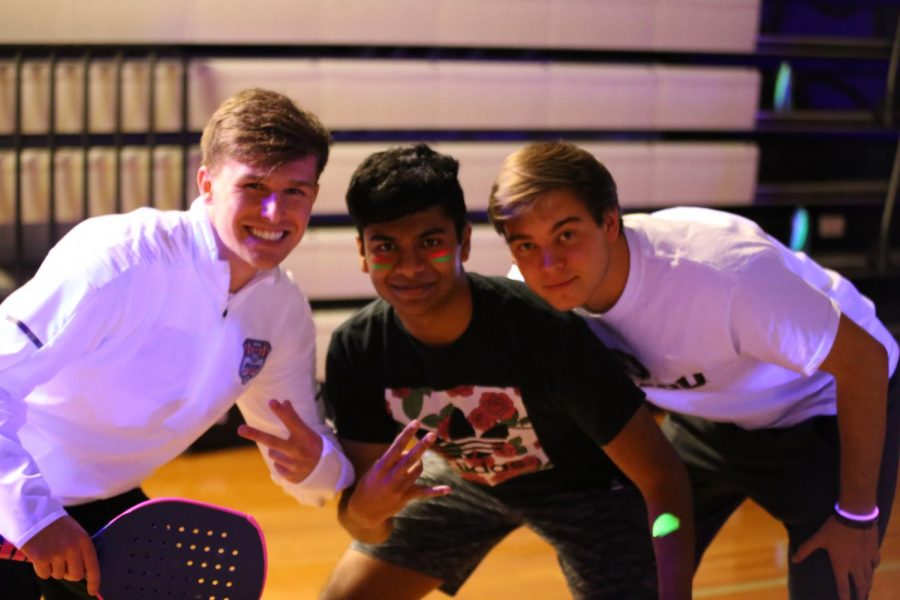 Senior Maclain Petri, Junior Karthik Satish and Senior Jake Traen smile on the court.