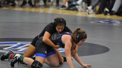 Sophomore Hannah Glynn wraps her arms around her opponent trying to tackle her to the ground.