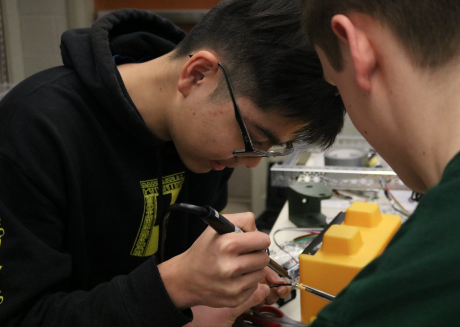 Senior Andrew Jin focuses on repairing the robot in his drafting class.