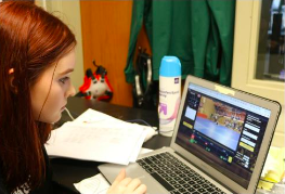 Wrestling manager Alyssa Krahenbuhl rewatches the videos from a previous competition to make sure the stats are correct.