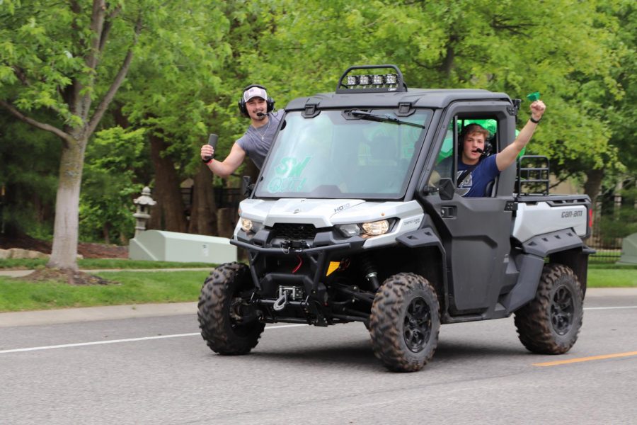 Hands out the window, seniors Stefan Freeman and Michael Paule ride on a Polaris during the parade on May 17. The parade took place on what would have been graduation day, which was postponed due to the COVID-19 pandemic. Photo by Lianna Shoikhet.