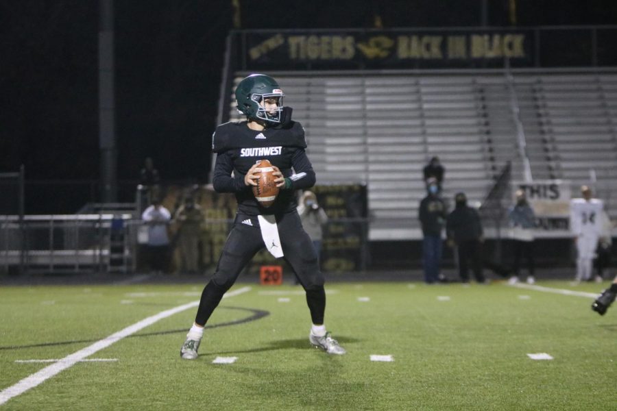 On Oct. 16, senior Tanner Curry decides who to throw the ball to at the varsity football game against Blue Valley High.