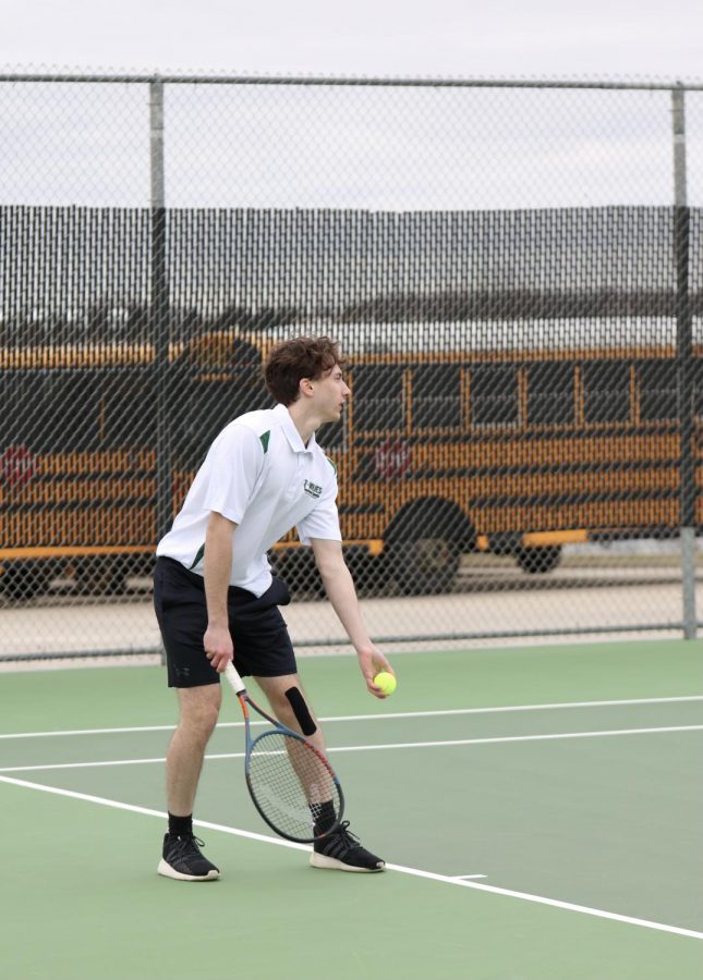 In the JV tennis match on March 24, Senior Matthew Young prepares to serve the ball to his opponent.