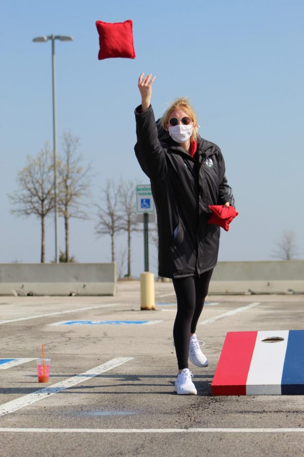 Fingers in the air, senior Merritt Ellis releases the cornhole bag at Cornhole For a Cure on April 24, 2021. Cornhole for a Cure was put on by members of Hoops 4 Hope, Wolf Pack Crew, and Student Council to help in the fight to #CrushKidCancer.  