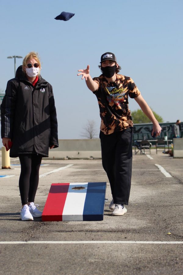 With an outstretched arm, senior Keithan Sharp tosses one of his cornhole bags at Cornhole for a Cure on April 24, 2021. Sharp played with senior Lauren Weber as his partner. 