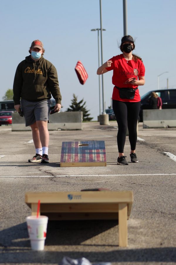 Watching her cornhole bag fly, senior Anna Comstock competes in Cornhole for a Cure on April 24, 2021. Cornhole for a Cure consisted of two sessions where the winners of each session competed against each other at the end. 