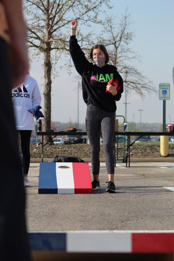 Hand in the air, senior Alex Ogren celebrates her successful throw at Cornhole for a Cure on April 24, 2021. Ogren participated in Cornhole for a Cure as a competitor as well as a member of Wolf Pack Crew and Student Council. 