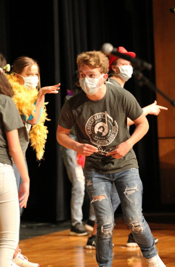 Sunglasses in hand, junior Sam Illum looks to his peers as he performs on stage.