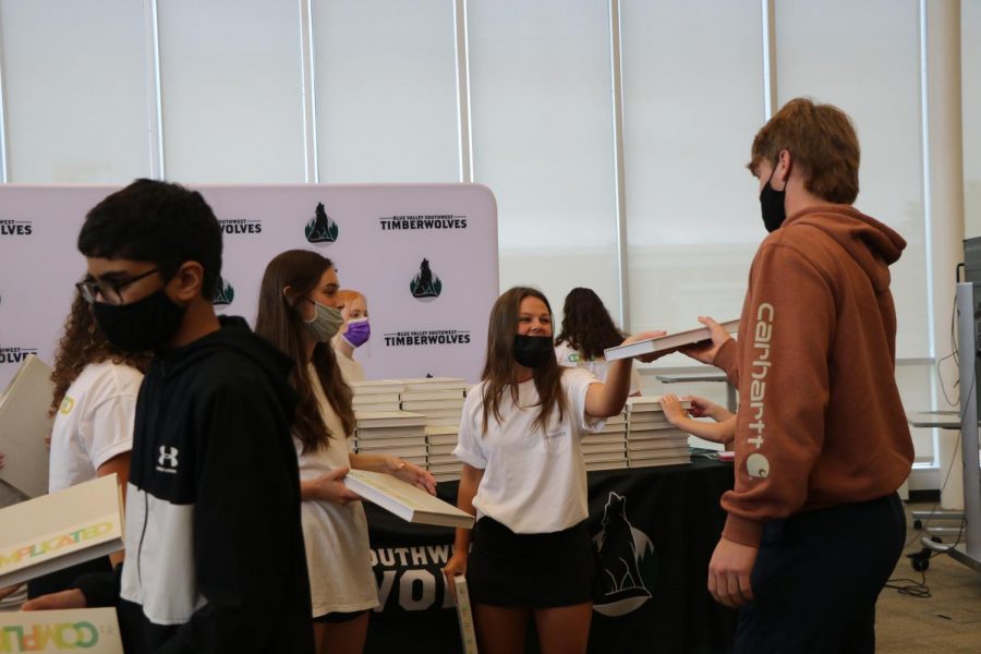 With a smile, senior Sydney Meschwitz gives junior Ben Bybee a copy of the yearbook on Distribution Day on May 19.