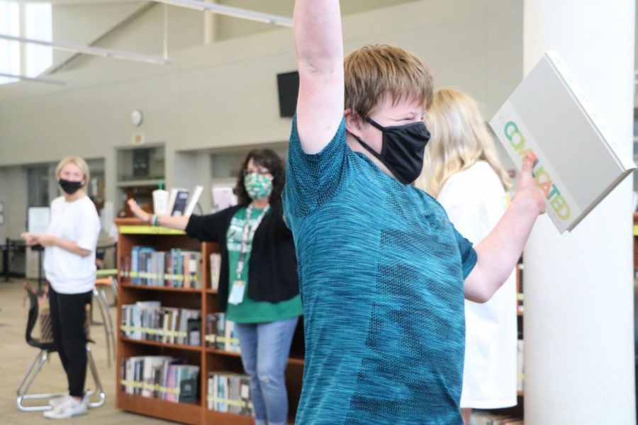 Hand in air, junior Kessler Sweat receives his book on Distribution Day on May 19.