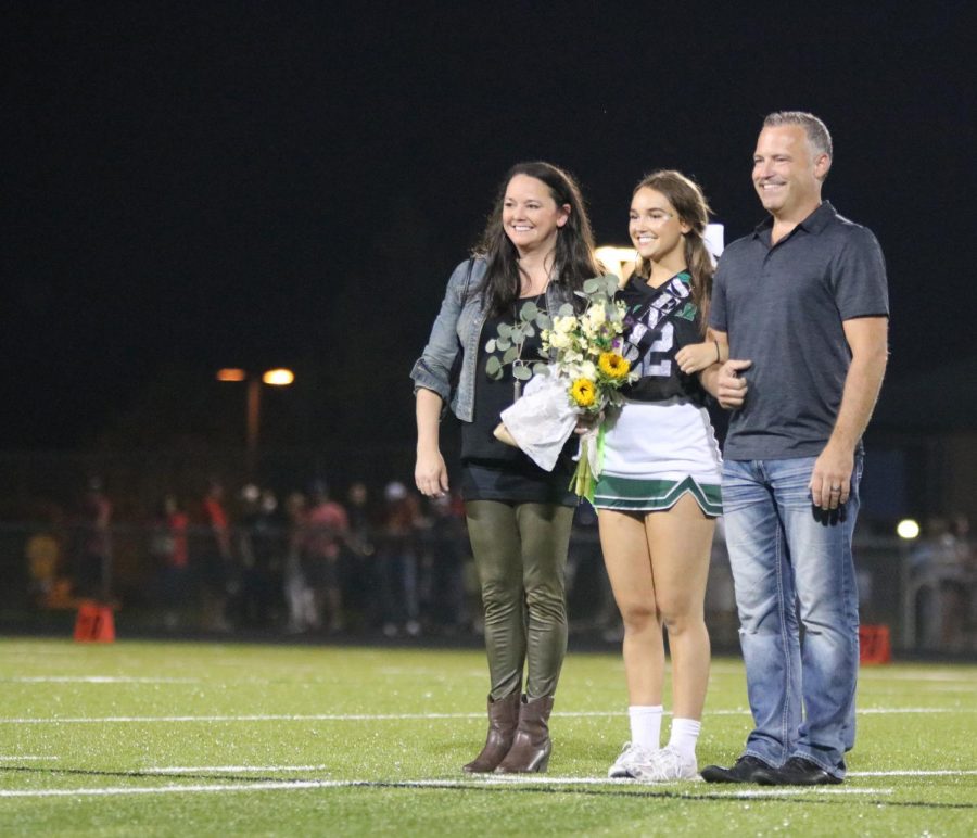 Standing with her parents, senior Grace Nab is recognized along with the other senior cheerleaders on Sept. 3.