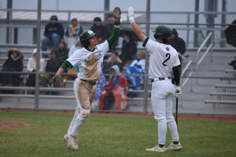 Senior Gavin Wakefield gives his teammate a high-five after he finishes running the bases.