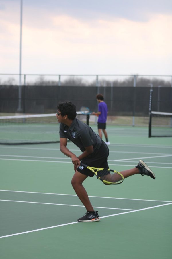 Junior Jedrick Wilson goes for a backhand in a doubles match.
