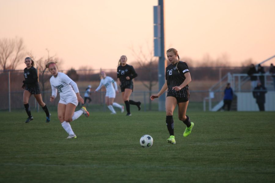 Junior Channing Bahr runs alongside the ball as she defends her team's goal from DeSoto.