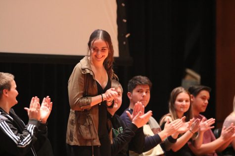 Senior Amy McKinsey looks out to the crowd as peers clap for her during the Performing Arts Ceremony. 