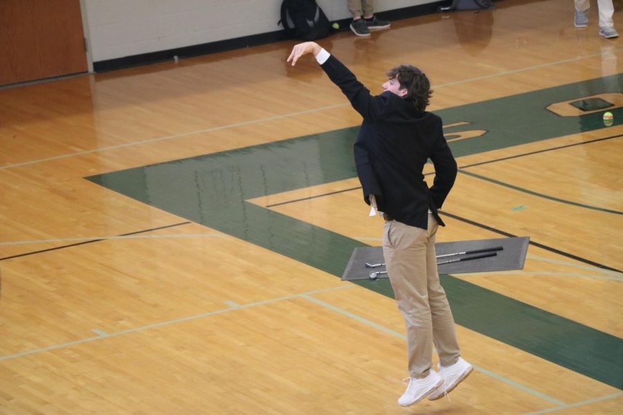 Tyler Sardelli shoots a basket in his suit while waiting to leave with the baseball team for a game.