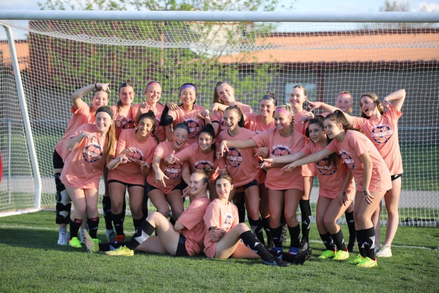 Pointing to the seniors, the girls varsity team gets together for a group photo on Senior Night on April 20. The girls wore their Senior Night shirts as practice shirts before the game.