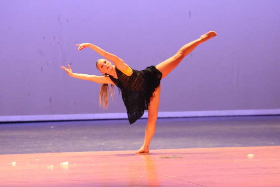 Hands reaching out, senior Maci Minton dances throughout her solo during the spring showcase on April 7.