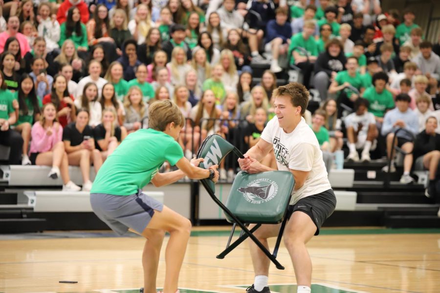 Senior Joseph Lochner fights for final chair against freshman Cameron Paschke during the game of musical chairs on April 21. Lochner was successful taking the win. photo by Hannah Porter 