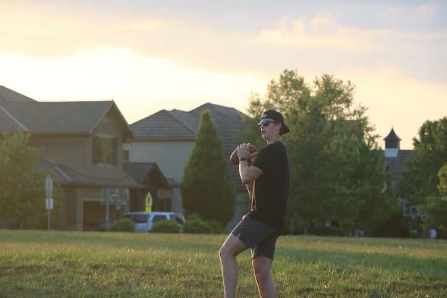 Ready to throw, Senior Miles Wirth plays catch with his friends during the senior sunset. 