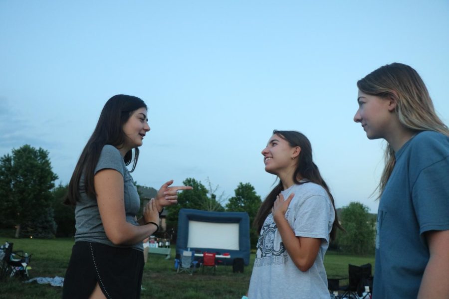 Talking with friends, senior Lila Schwarz listens to a story told by senior Lexi Becton on May 17. 