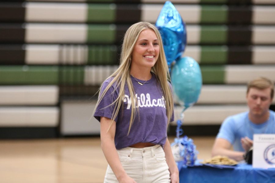 Senior Maci Minton with a smile on her face going to leave her mark on the book during the Signing Day ceremony on May 9. Minton will be attending Kansas State after high school.