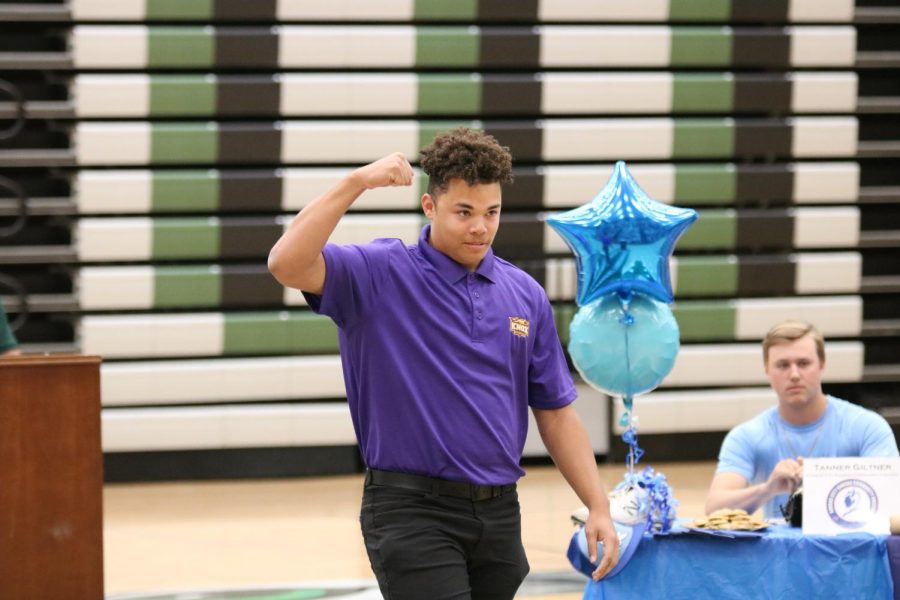 Senior Jacob Dickey celebrating the accomplishment on the way to leave his signature at the Signing Day ceremony on May 9. Dickey will be attending Knox College after high school.